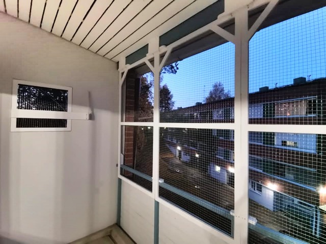 Valkoiseksi maalattu parveke, jossa metalliverkko estämässä kissan putoamista. Putoaminen on aina vaarallista kissalle. 